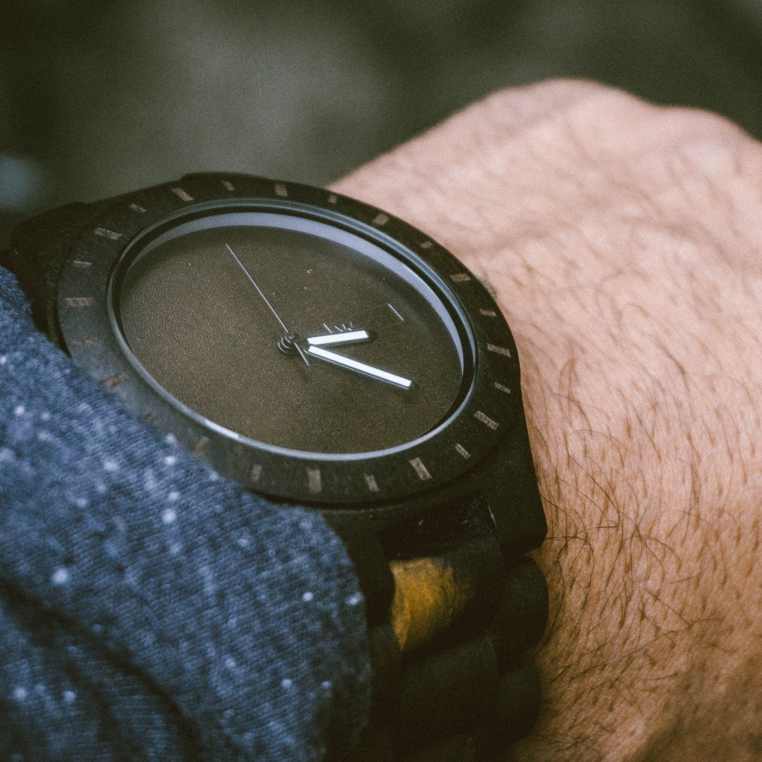 Close detail of the Anvil watch case and leather strap, worn on the wrist