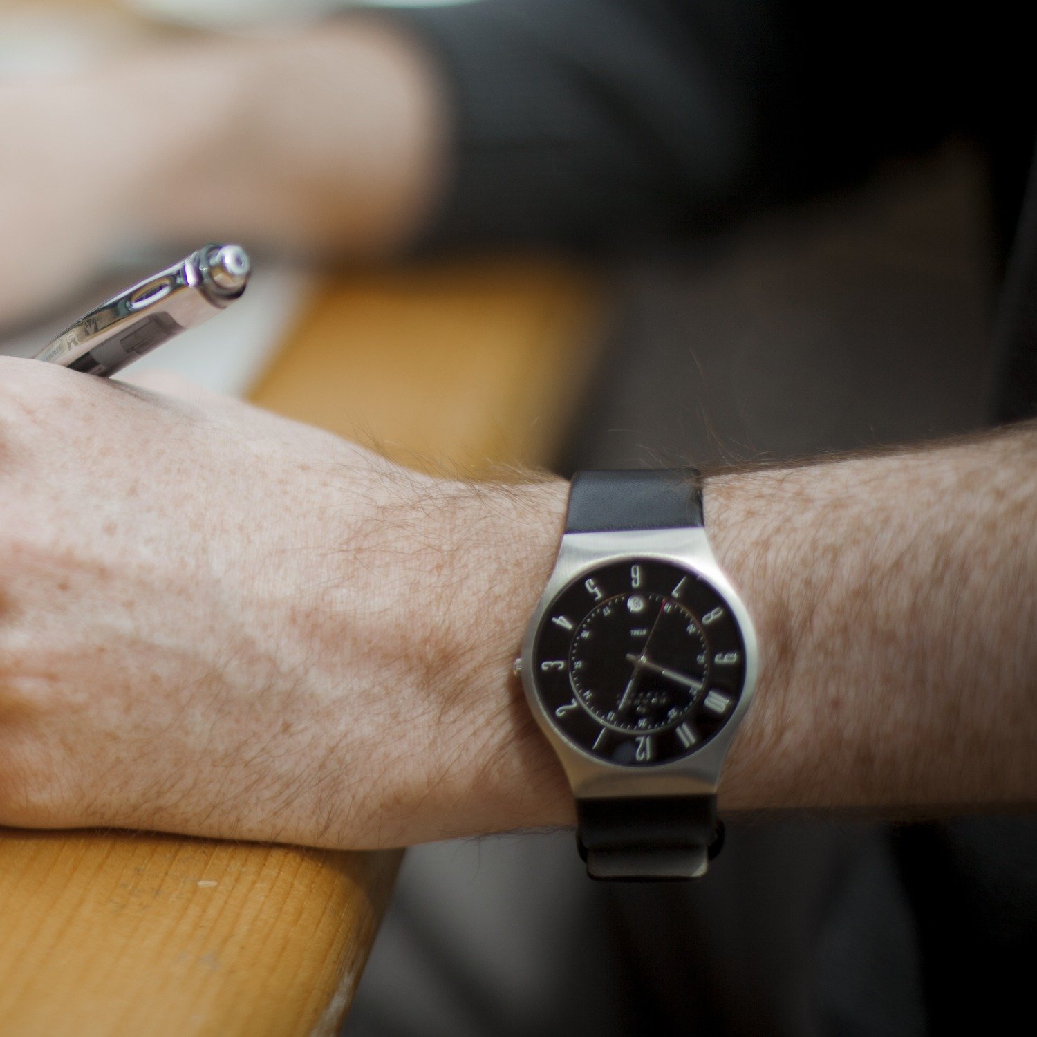The Akokowaa Sentinel, a black-dial watch on a black leather strap, worn on the wrist
